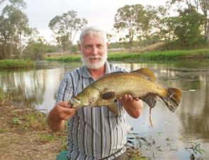 Gladstone Sportsfishing Club member John Platten with a typical barramundi caught in the lake.